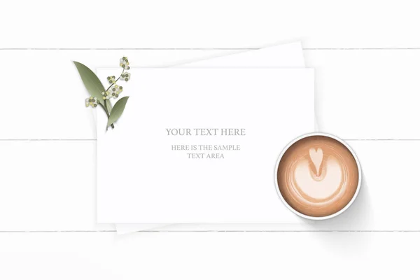 Flat lay top view elegant white composition paper plant leaf flower and coffee on wooden background.