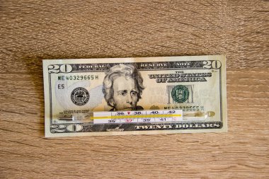 Masada 20 dolar var ve üzerinde bir termometre var. Para masanın üzerinde ve üzerinde ekonomik krizin sembolü olarak bir termometre var..