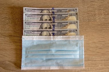Dolarlar klinikteki maskenin altında yatıyor. Amerikan parası koruyucu maskenin altında yatıyor..