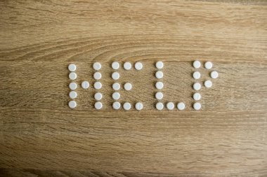 Yardım kelimesi ahşap bir masanın üzerine serilmiştir. 