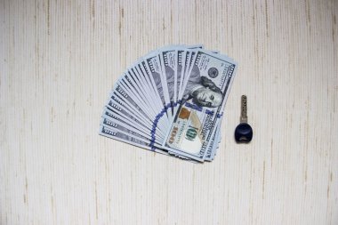 Dairenin anahtarı bir yığın paranın yanında yatıyor. Anahtarlı para odadaki masanın üstünde.. 