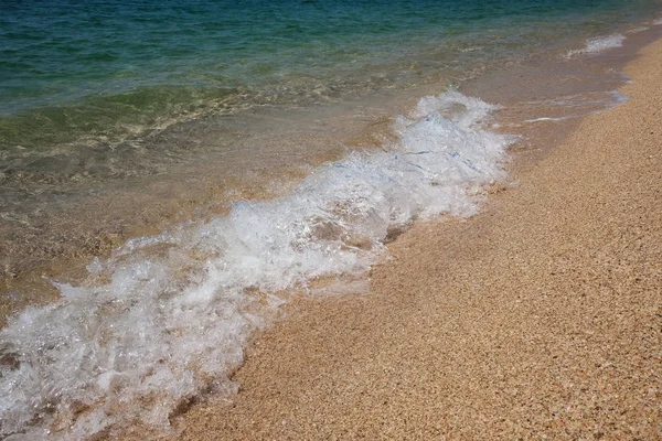 Altın kum ile bir plajda bir deniz dalgası bir close-up ile manzara