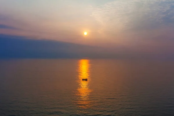 Gün batımında denizde yalnız tekne — Stok fotoğraf