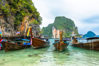 Krabi eyaletinde kayaların arka planda Tay tarzı tekneler
