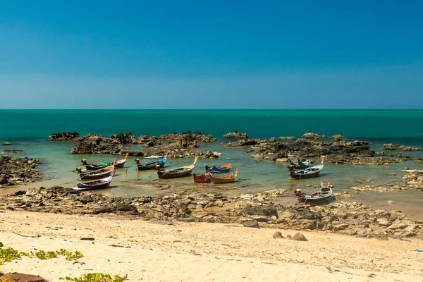 Tayland taşlı bir deniz kıyısında renkli tekneler