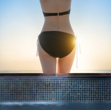 Deniz kıyısındaki yüzme havuzunda bikinili ince bir kadın cesedi. Yaz tatilinin tadını çıkar.