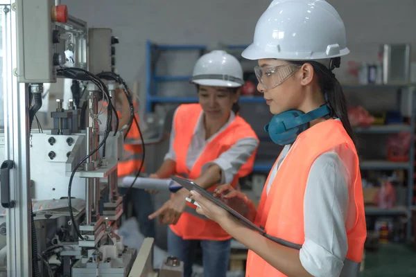 women working engineering or technical inspection the system  of machinery to ensure working in order by checklist part and quality control