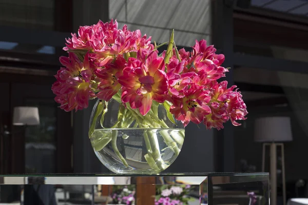 ガラスに咲くチューリップ ラウンド花瓶スタンド カフェへの入り口 — ストック写真