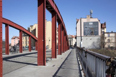 Jordan köprü Poznan Ostrow Tumski adada. Açık bir günde üzerinde arka planda bir kilise ile kırmızı bir köprü.