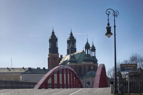 Jordan most na wyspie Ostrów Tumski w Poznaniu. Czerwony most z Kościołem w tle w pogodny dzień. — Zdjęcie stockowe