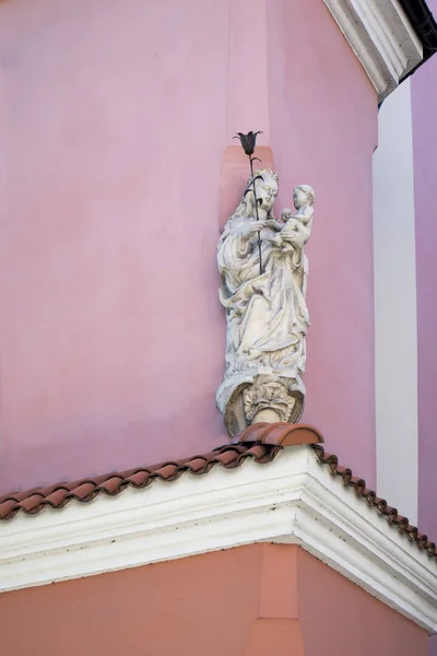 Posąg Marii Panny z dzieckiem w ramionach dekoracji różowy rogu budynku — Zdjęcie stockowe