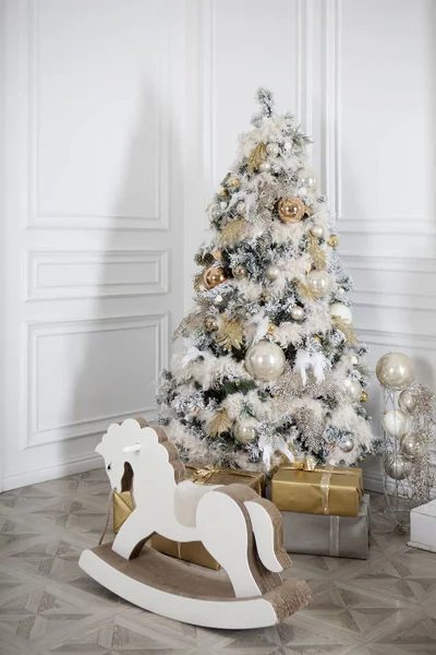 Toy wooden rocking horse in the New Year's interior. New Year's decorations. Decoration of the house. White wooden rocking horse.