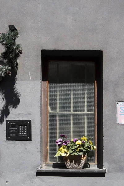 スミレ、チューリップ、菊、ユリの谷、キンポウゲの人工的な花束のバスケットは、レストランへの入り口を飾る — ストック写真