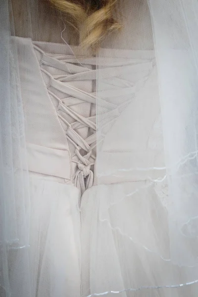 Hermosa novia atando su vestido de novia — Foto de Stock