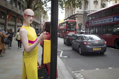 London, Büyük Britanya - 14 Eylül 2018: Londra Moda Haftası sırasında sokakta insanlar. Sokağın aşağısında üç travesti yürüyüş