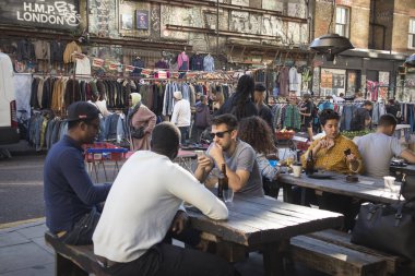 Londra, İngiltere - 14 Eylül 2018: Bricklane Doğu Londra'da sokakta insanlar. İnsanlar sokak bir kafede bir masada oturmak.