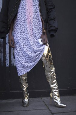 London, Büyük Britanya - 14 Eylül 2018: Londra Moda Haftası sırasında sokakta insanlar. Mavi çiçek, siyah bombardıman ceket, beyaz kaşkollu ve altın topuklu botlarla beyaz elbiseli kız