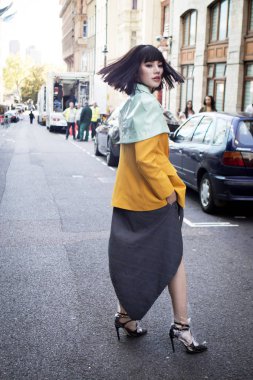 Londra, İngiltere - 14 Eylül 2018: Londra Moda Haftası sırasında sokakta insanlar. Bir sarı ceket ve yeşil cape Çin blogger