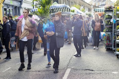 Londra, İngiltere - 12 Ekim 2018 grup genç arkadaşlar ünlü Brick Lane Londra'da yürüyüş. Karışık ırklar birlikte eğleniyor renkli kıyafetlerle çok kültürlü insanlarla. Öğrenciler ya da turist olabilir