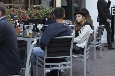 Londra, İngiltere - 15 Eylül 2018 bir bere kız sokak bir kafede oturuyor, bira içiyor