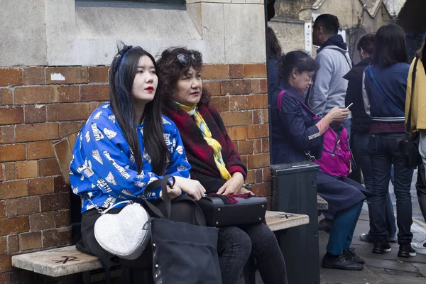 Londres Inglaterra Noviembre 2018 Dos Chicas Asiáticas Están Sentadas Banco — Foto de Stock