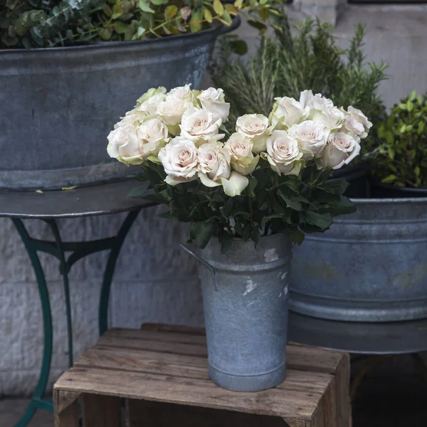 Vita rosor på en pall vid ingången till blomsteraffär — Stockfoto