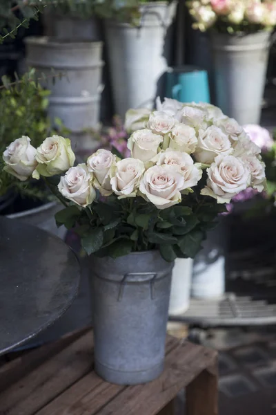 Белые розы на стуле у входа в цветочный магазин — стоковое фото