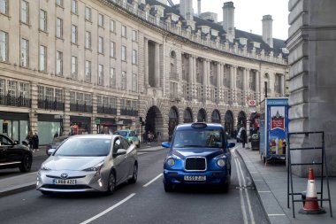 Bir taksi ve Regent Caddesi girişinde bir Londra otobüsü