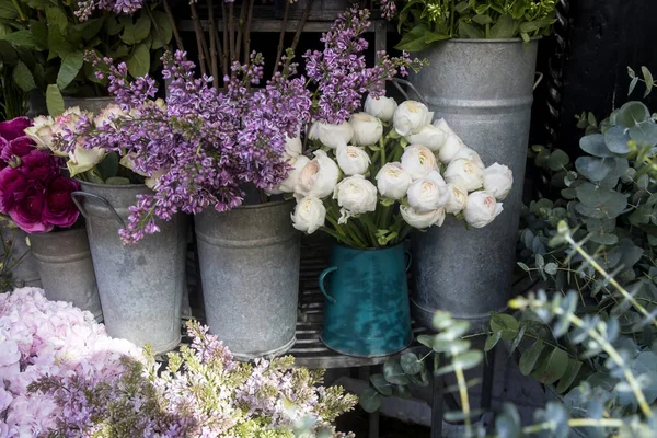 Bouquet di ranuncolo lilla e bianco in secchi di latta in vendita all'ingresso del negozio — Foto Stock