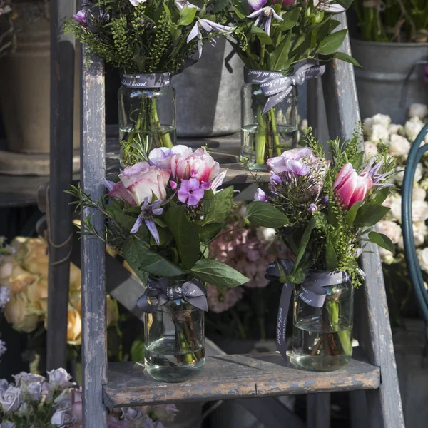 Bouquet of roses and lilac hydrangea on an ladder near the entrance to the store as a decoration — Stock Photo, Image