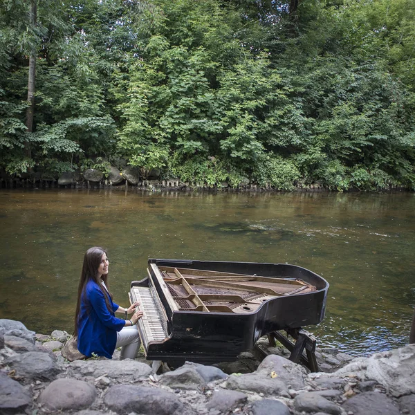 Εγκαταλειμμένο Γκραν πιάνο, ερειπωμένο πιάνο από μια όχθη ποταμού (ποταμός Vilnia) στην συνοικία των καλλιτεχνών Uzupis στο Βίλνιους, τη Λιθουανία, την ατμόσφαιρα της μποέμ. Δημοκρατία της Ουζάπης — Φωτογραφία Αρχείου