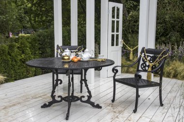 Tea set on the table in the garden. Landscape Design