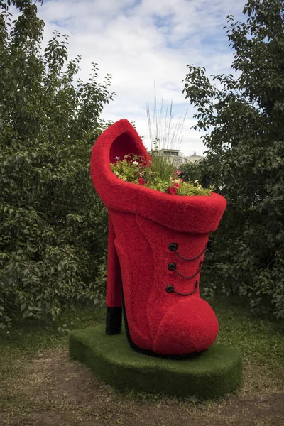 Macizo de flores en forma de zapato rojo alto con petunias decora el jardín —  Fotos de Stock