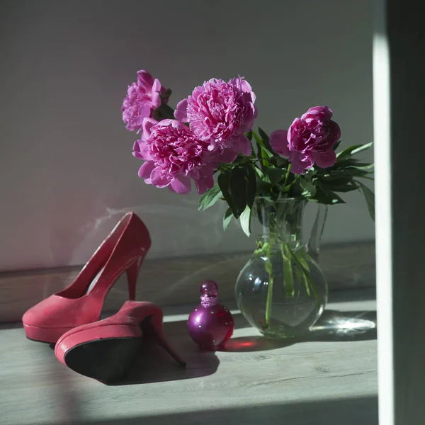 Bouquet of pink peonies in a glass transparent vase on the floor — Stock Photo, Image