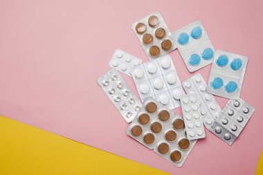 pembe tıp hapları çok. İlaç hapları blister paketleri kazık, farklı renkler, sarı arka plan. Tedavi ilaçları için ilaç reçetesi. Antibiyotik ağrı kesici.
