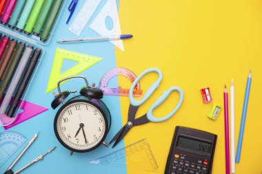 Okul başlangıç, okula geri, eğitim mavi ve sarı üzerinde okul malzemeleri ile düz sahne yatıyordu tarzı