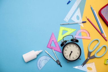 Okul başlangıç, okula geri, eğitim mavi ve sarı üzerinde okul malzemeleri ile düz sahne yatıyordu tarzı
