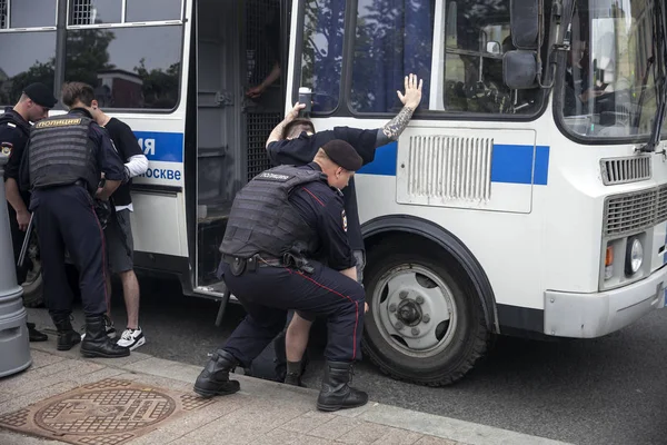 Law enforcement officers detain participant during rally. Police and hundreds of demonstrators faced off in central Moscow during unauthorized march — Stock Photo, Image