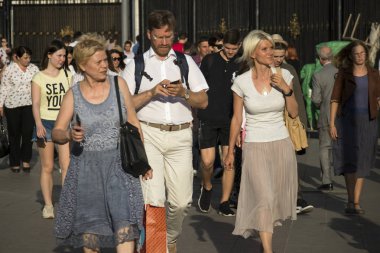 Güneşli bir günde büyük bir kalabalık metrodan çıkıyor.
