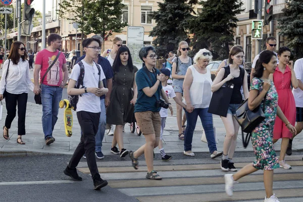 Una multitud de personas cruzando la calle en los semáforos — Foto de Stock