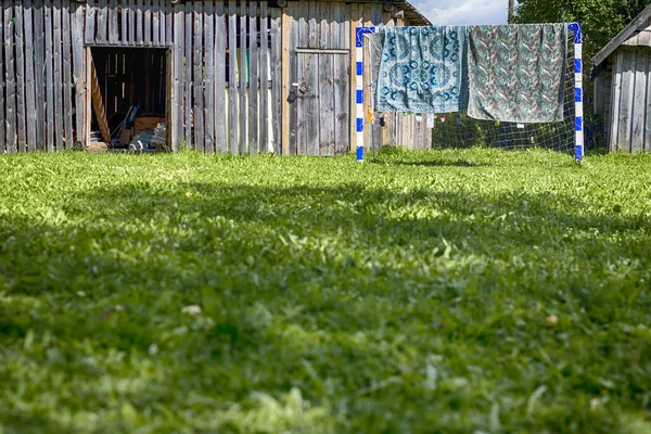 Dwa Dywaniki gobelin wiszą na bramkę piłkarską w wiosce — Zdjęcie stockowe