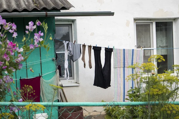 ロシアの村の古い木造住宅を背景に、女性の古いリネンが乾燥 — ストック写真