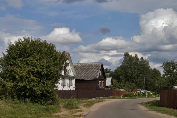 俄罗斯村庄的景色，有木屋和乡村道路 — 图库照片