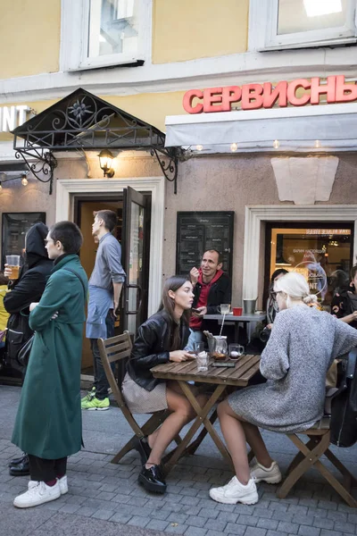 Besökare till caféet fortsätter att äta, medan polisen kör folk från gatan i tunnelbanan — Stockfoto