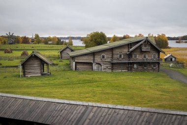 Karelia, Rusya - 27 Ağustos 2019: Şekil Değiştirme Kilisesi ve Rusya 'nın Karelia bölgesindeki Kizhi adasındaki çiftlik evi manzaralı gün batımı manzarası