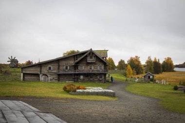 Karelia, Rusya - 27 Ağustos 2019: Şekil Değiştirme Kilisesi ve Rusya 'nın Karelia bölgesindeki Kizhi adasındaki çiftlik evi manzaralı gün batımı manzarası