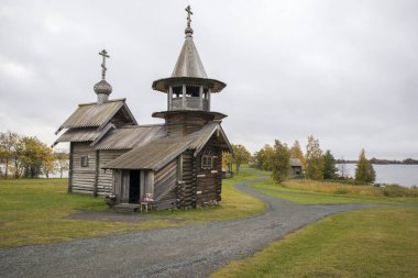 Karelia, Rusya - 27 Ağustos 2019: Şekil Değiştirme Kilisesi ve Rusya 'nın Karelia bölgesindeki Kizhi adasındaki çiftlik evi manzaralı gün batımı manzarası
