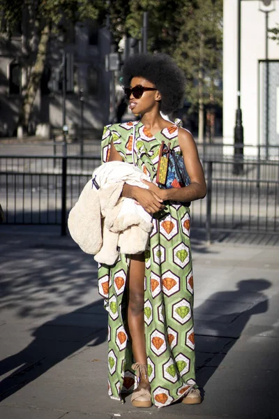 LONDON, UK- SEPTEMBER 13 2019: People on the street during the London Fashion Week. Woman in a long dress with an African print. — Stock Photo, Image