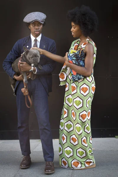 LONDRES, Reino Unido 13 DE SEPTIEMBRE DE 2019: La gente en la calle durante la Semana de la Moda de Londres. Un hombre con gorra y un traje clásico con un bulldog en los brazos. Mujer en vestido largo con estampado africano . —  Fotos de Stock