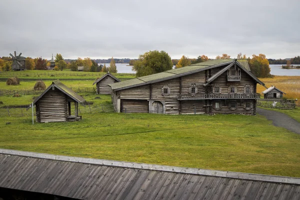 Karelia, Rosja - sierpień 27, 2019: Zachód słońca z widokiem na Kościół Przemienienia Pańskiego i dom rustykalny na wyspie Kizhi, obwód Karelia, Rosja w deszczu — Zdjęcie stockowe